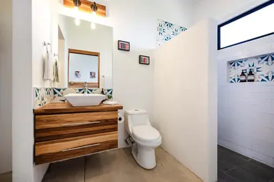 a white bathroom with a sink and a toilet at Villa Serenity 4 bedroom 1 min walk to the beach in Santa Cruz