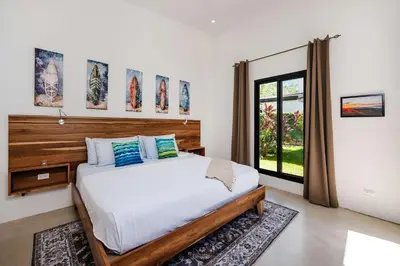 a bedroom with a large bed and a window at Villa Serenity 4 bedroom 1 min walk to the beach in Santa Cruz