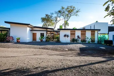 a white house with a gravel driveway at Villa Serenity 4 bedroom 1 min walk to the beach in Santa Cruz