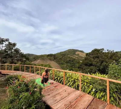 a person sitting on a wooden bridge with a skateboard at Alas Romantic Chalet Monteverde in Monteverde Costa Rica