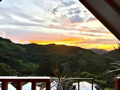 a view of a sunset from a house with a mountain at Alas Romantic Chalet Monteverde in Monteverde Costa Rica
