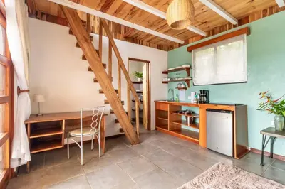 a kitchen with a staircase and a table and chairs at Alas Romantic Chalet Monteverde in Monteverde Costa Rica