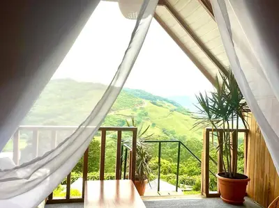 a room with a balcony with a view of a mountain at Alas Romantic Chalet Monteverde in Monteverde Costa Rica