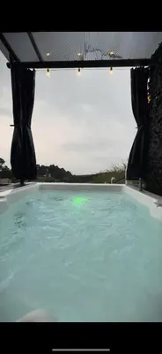 a large pool of blue water with a large window at Ventana Paraíso Cabaña con Jacuzzi in Alajuela City
