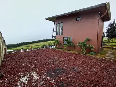 a house with a large pile of red gravel at Ventana Paraíso Cabaña con Jacuzzi in Alajuela City