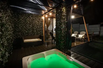 a room with a bath tub on a deck at night at Ventana Paraíso Cabaña con Jacuzzi in Alajuela City