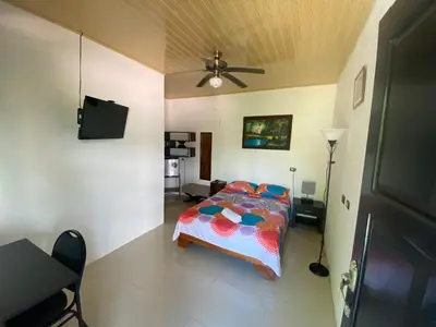 a bedroom with a bed and a ceiling fan at Tropical Sunset Villas in Uvita