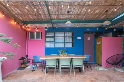 a table and chairs in a room with pink and blue walls at Casa Zafiro B&B in San José