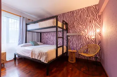 a bedroom with a bunk bed and a chair at Casa Zafiro B&B in San José