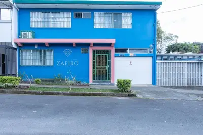 a blue building with a door and a gate at Casa Zafiro B&B in San José