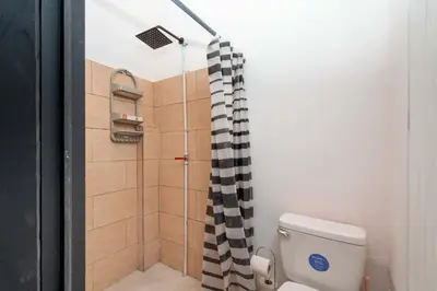 a bathroom with a shower with a black and white shower curtain at Apartamento Frigia 3 in Quepos