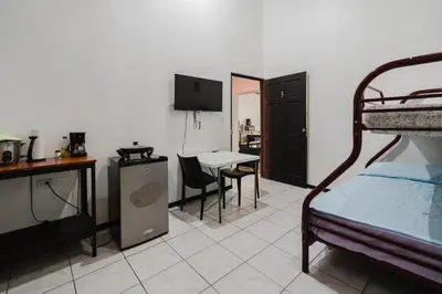 a room with a bed and a desk and a table at Apartamento Frigia 3 in Quepos