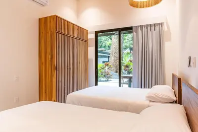 a bedroom with two beds and a window at Coco Nosara Villas Guiones Family Resort Casa Rubi in Nicoya