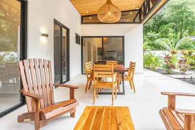 a dining room with wooden chairs and a table at Coco Nosara Villas Guiones Family Resort Casa Rubi in Nicoya