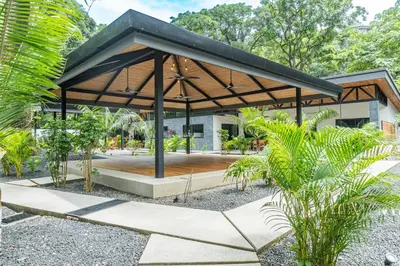 a pavilion with a wooden floor in a park at Coco Nosara Villas Guiones Family Resort Casa Rubi in Nicoya