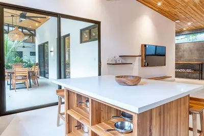 an open kitchen with a large island with a white counter top at Coco Nosara Villas Guiones Family Resort Casa Rubi in Nicoya