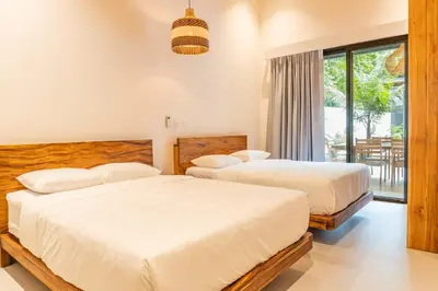 a bedroom with two beds and a balcony at Coco Nosara Villas Guiones Family Resort Casa Juan in Nicoya