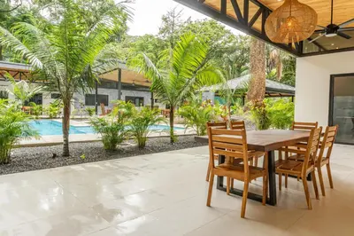 a dining room with a table and chairs and a pool at Coco Nosara Villas Guiones Family Resort Casa Juan in Nicoya