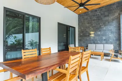 a dining room with a wooden table and chairs at Coco Nosara Villas Guiones Family Resort Casa Juan in Nicoya