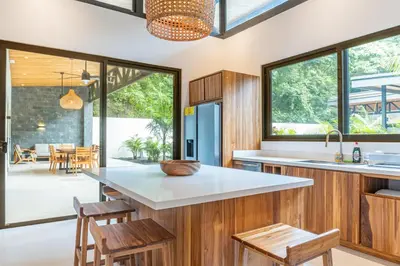 an open kitchen with wood paneling and a large window at Coco Nosara Villas Guiones Family Resort Casa Juan in Nicoya