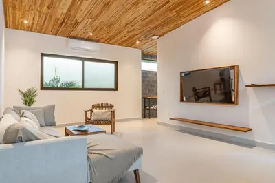 a living room with a couch and a tv at Coco Nosara Villas Guiones Family Resort Casa Juan in Nicoya