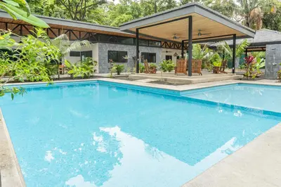 a large swimming pool in front of a house at Coco Nosara Villas Guiones Family Resort Casa Lluvia in Nicoya