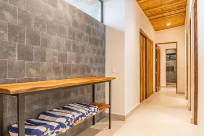 a room with a stone wall and benches at Coco Nosara Villas Guiones Family Resort Casa Marie in Nicoya