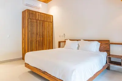 a bedroom with a large bed with a wooden headboard at Coco Nosara Villas Guiones Family Resort Casa Marie in Nicoya