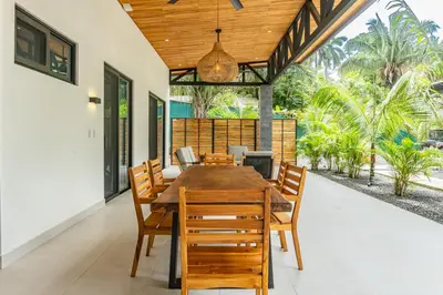 a dining room with a wooden table and chairs at Coco Nosara Villas Guiones Family Resort Casa Marie in Nicoya