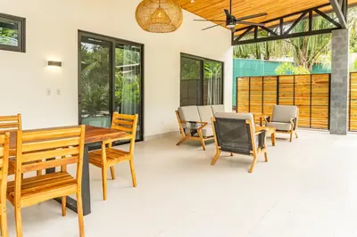 a dining room with a wooden table and chairs at Coco Nosara Villas Guiones Family Resort Casa Marie in Nicoya