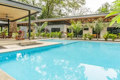 a large swimming pool in front of a house at Coco Nosara Villas Guiones Family Resort Casa Marie in Nicoya