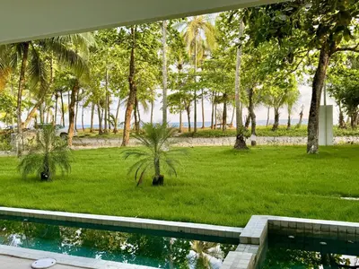 a swimming pool in a yard with palm trees at Esterillos Lote home in Esterillos