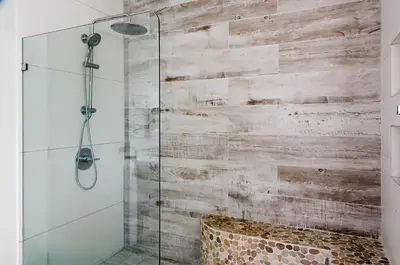 a bathroom with a shower with a wooden wall at Esterillos Lote home in Esterillos