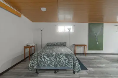 a bedroom with a bed with a green blanket on it at Pizote Apartment Monteverde 2nd floor in Monteverde Costa Rica