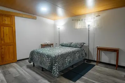 a bedroom with a bed and two lamps and a door at Pizote Apartment Monteverde 2nd floor in Monteverde Costa Rica