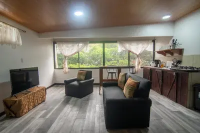 a living room with two chairs and a couch and a television at Pizote Apartment Monteverde 2nd floor in Monteverde Costa Rica