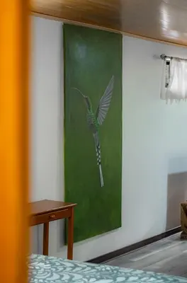 a painting of a humming bird on a wall at Pizote Apartment Monteverde 2nd floor in Monteverde Costa Rica