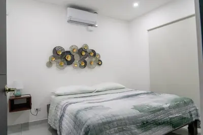 a bedroom with a bed and a white wall at Gival Paradise in Fortuna