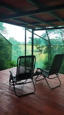 two chairs sitting on top of a wooden deck at Glamping Butterflay Garden in Concepción