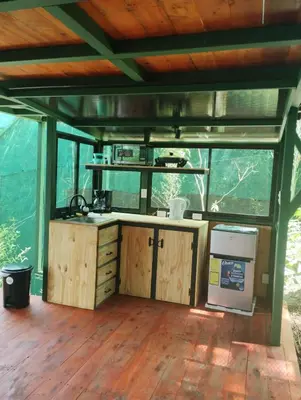 a kitchen in a house with wooden floors and ceilings at Glamping Butterflay Garden in Concepción