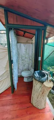 a bathroom with a toilet in a tent at Glamping Butterflay Garden in Concepción