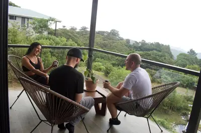 a group of three people sitting around a table on a balcony at Casa Horizonte Verde in Cebadilla