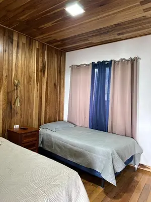 two beds in a room with wooden walls at Casa Horizonte Verde in Cebadilla