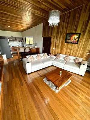 a living room with a white couch and a wooden floor at Casa Horizonte Verde in Cebadilla