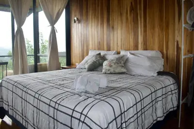 a bedroom with a bed with white sheets and pillows at Casa Horizonte Verde in Cebadilla