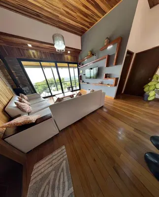 a large living room with a large couch and wood floors at Casa Horizonte Verde in Cebadilla