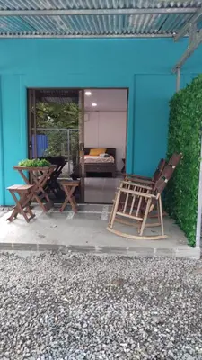 a pair of chairs and a table in front of a blue house at ApartCasa Full Budget Apart House near beach and rain forest in Uvita