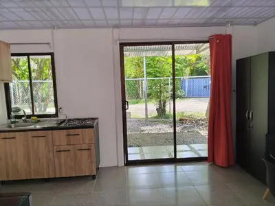 a kitchen with a sliding glass door to a yard at ApartCasa Full Budget Apart House near beach and rain forest in Uvita