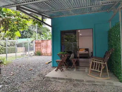 a blue house with two chairs and a table at ApartCasa Full Budget Apart House near beach and rain forest in Uvita