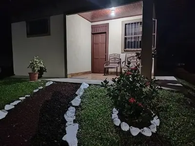 a house with a porch with chairs and a plant at Arenal Dreams House in Fortuna